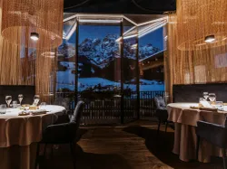 Elegantes Restaurant mit Bergblick und runden Tischen für feines Essen gedeckt