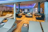 Moderner Spa-Loungebereich mit bequemen Liegen, runden Sofas, Kaminen und stimmungsvoller Beleuchtung