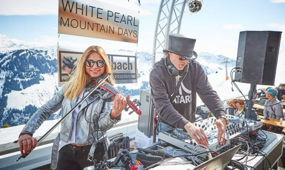 Live DJ and electric violin performance at White Pearl Mountain Days in snowy alpine setting