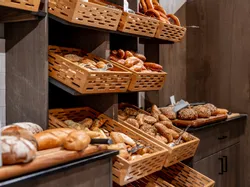 Verschiedene frische Brote und Brötchen in Holzkörben in einer Bäckerei