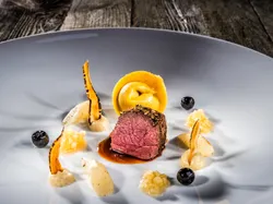 Gourmet-Rinderfilet mit Pasta, Wurzelgemüse, Püree und Blaubeeren kunstvoll angerichtet