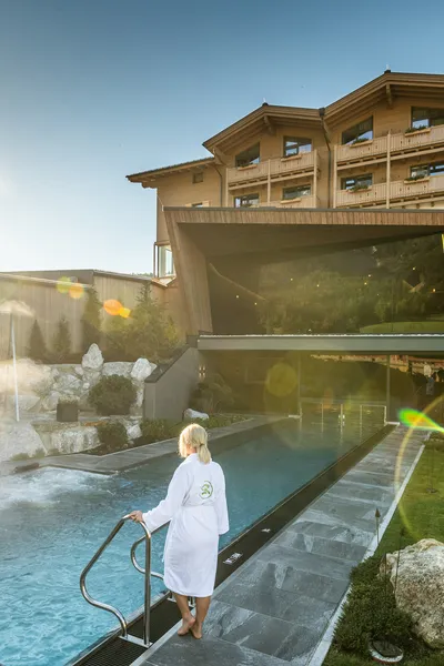 Luxus-Bergresort mit beheiztem Außenpool und Wellnessbereich bei Sonnenuntergang
